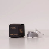 Routine Superstar mini deodorant showing black packaging with gold text next to open glass jar containing charcoal-grey natural deodorant with activated charcoal